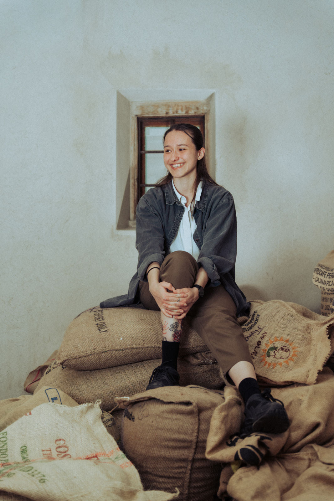 Cassandra, Quintacoira Barista auf Kaffeesäcke sitzend