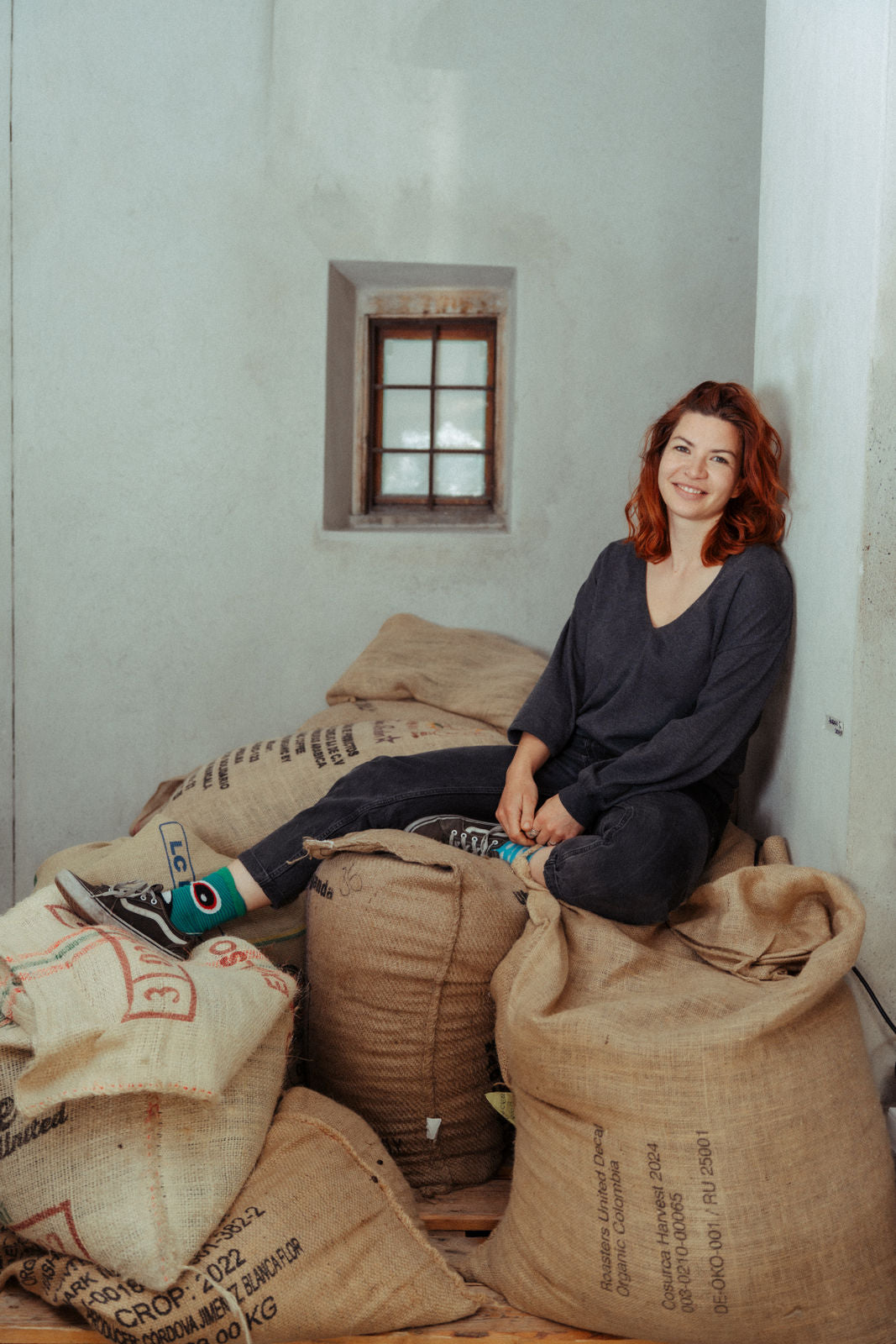 Katja, leger sitzend auf den Kaffeesäcken